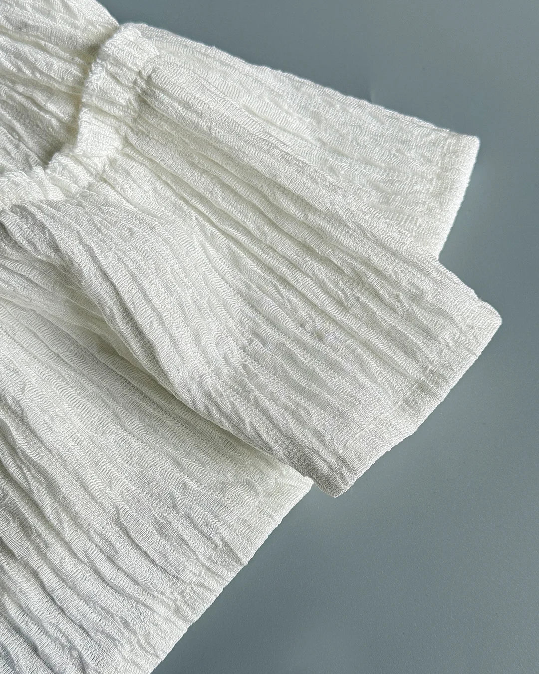 Close-up of textured white fabric on a gray background