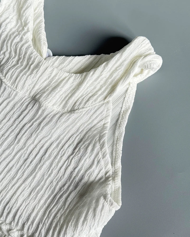 Close-up of a textured white garment against a gray background