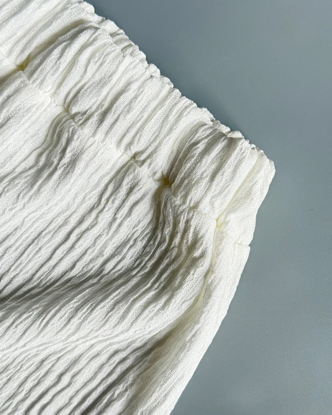 Close-up of textured white fabric on a gray background