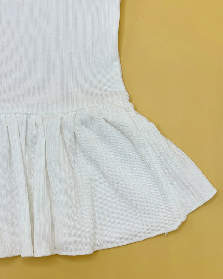 White pleated skirt on a mustard yellow background