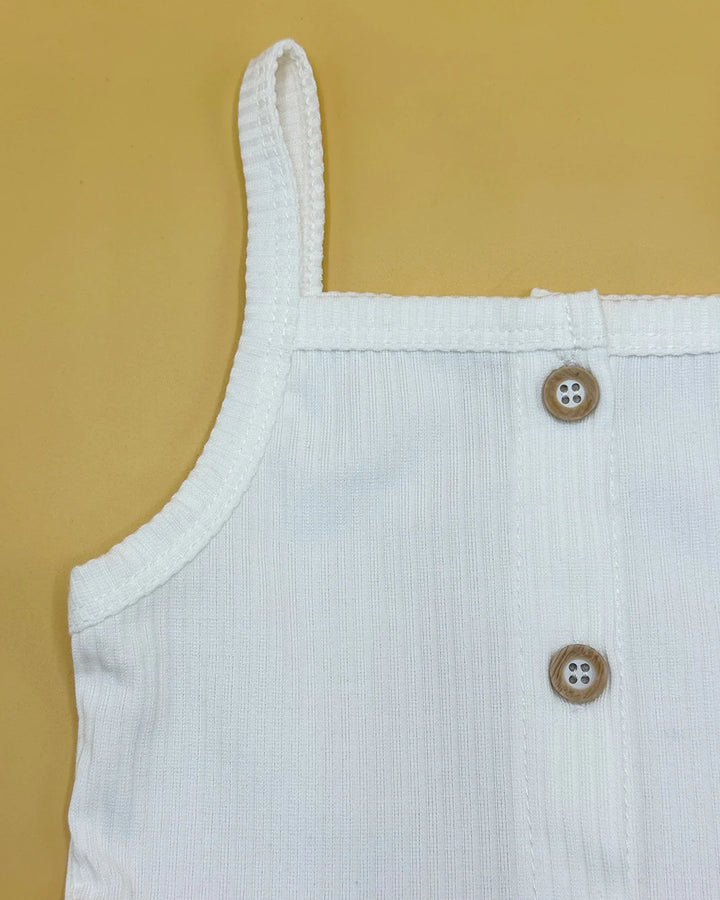 White sleeveless top with button details on a beige background