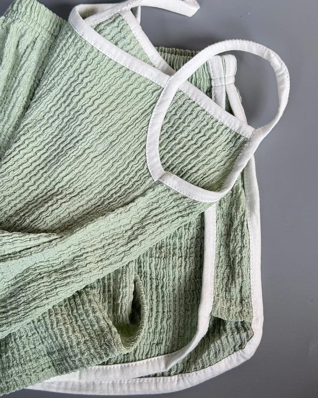 Green textured towel with white trim on a gray background