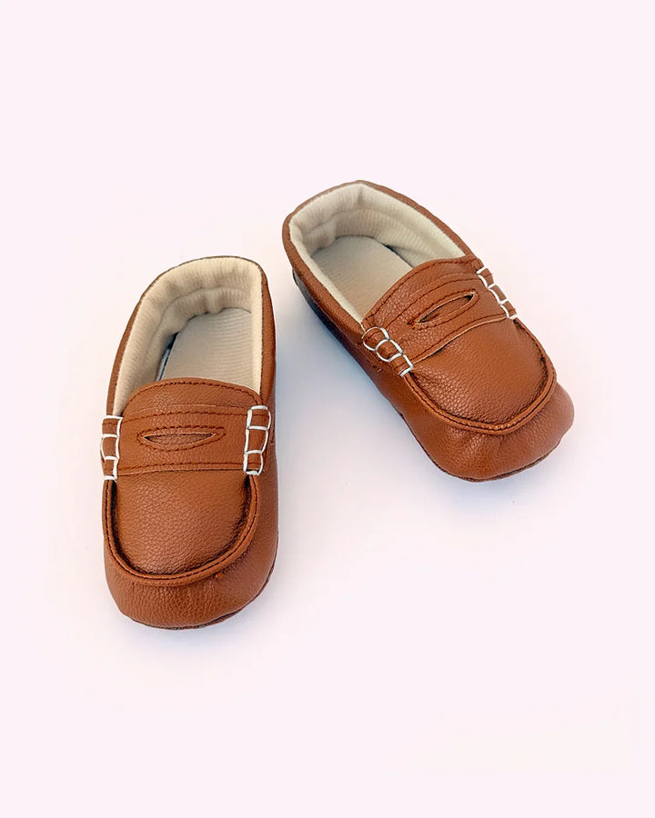 Pair of brown leather loafers on a white background