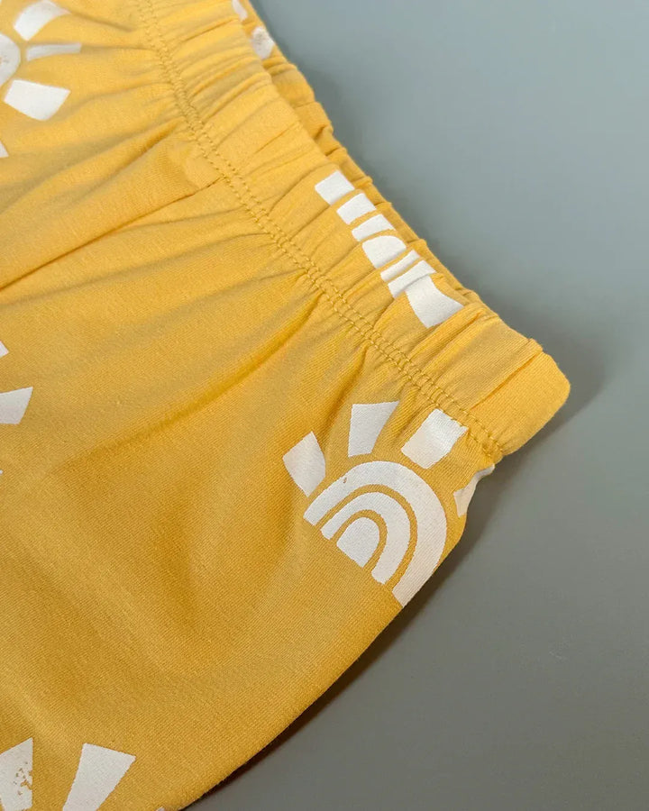 Yellow shorts with white logo on a gray background