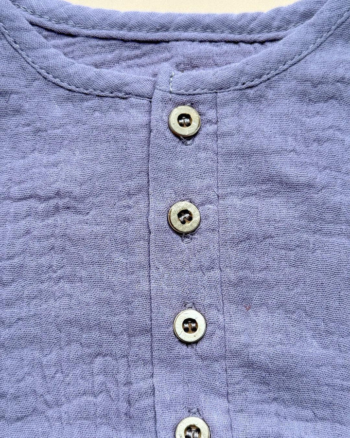 Close-up of a blue textured shirt with buttons