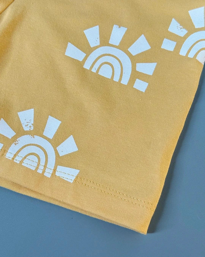 Yellow fabric with white sun and rainbow pattern on a blue background