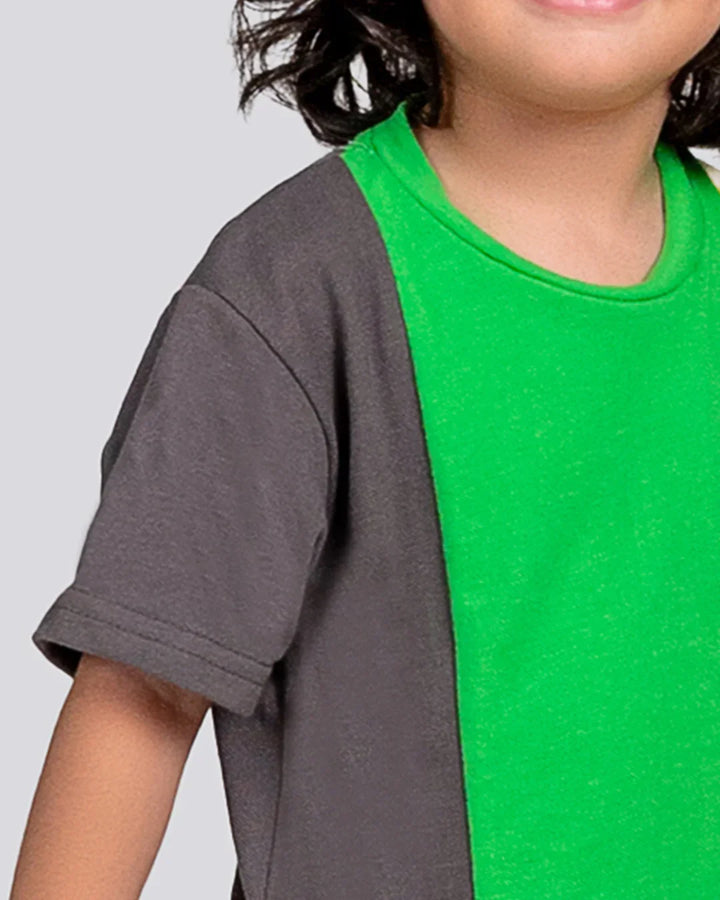 Child wearing a green and gray shirt on a plain background