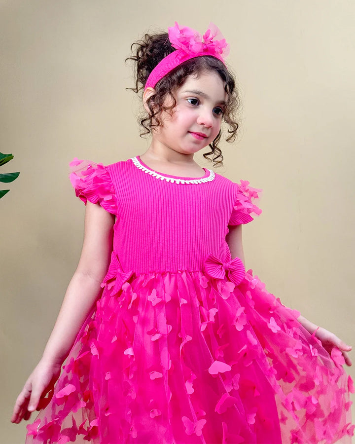 Young girl wearing a pink dress with ruffles and a headband on a beige background