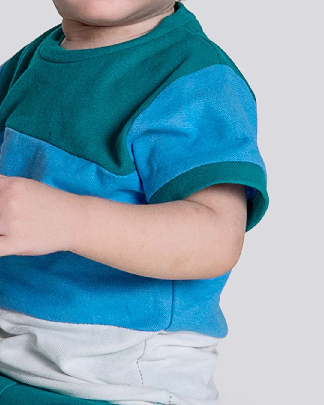 Child wearing a blue and green striped shirt on a plain background