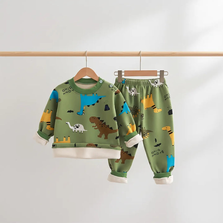 Children's dinosaur-themed pajama set on hangers against a light gray background