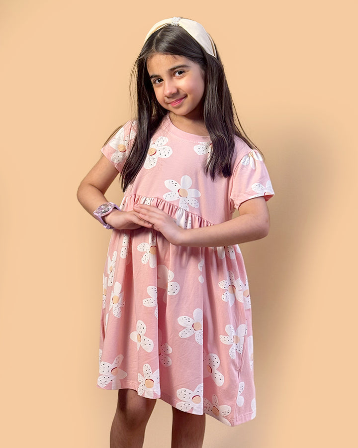 Young girl wearing a pink floral dress against a beige background