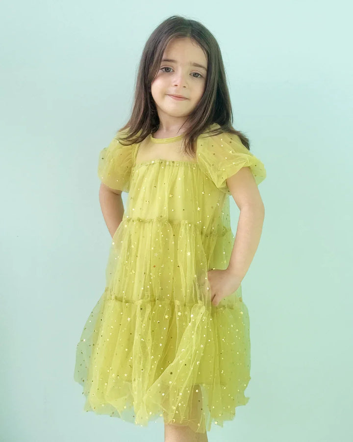 Young girl wearing a yellow dress with a light blue background