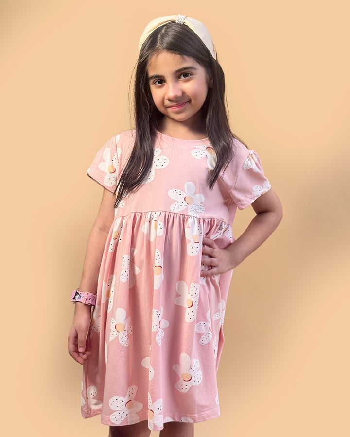 Young girl wearing a pink floral dress against a beige background