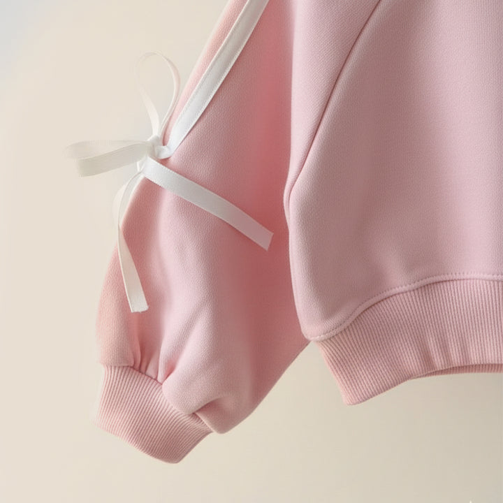 Pink hoodie with a white ribbon on a light beige background