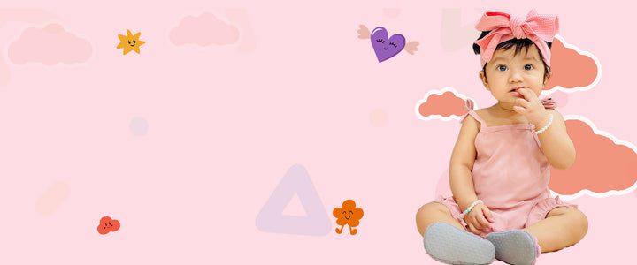 Baby in a pink outfit with a bow on a pink background with decorative elements