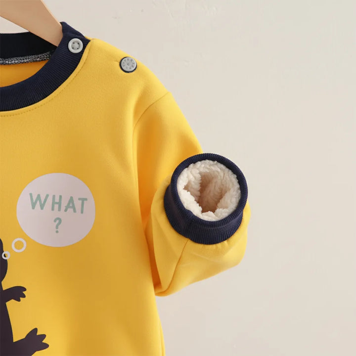 Yellow children's sweater with dark blue collar and cuffs on a beige background