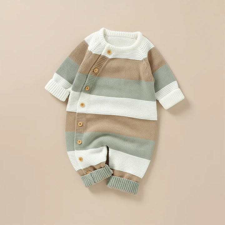 Striped baby romper with buttons on a beige background