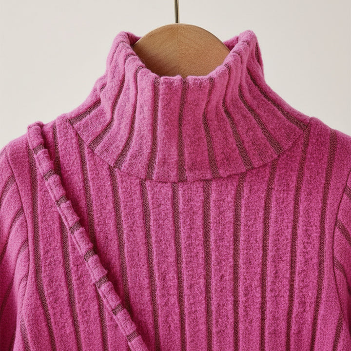 Close-up of a pink ribbed sweater on a hanger against a white background