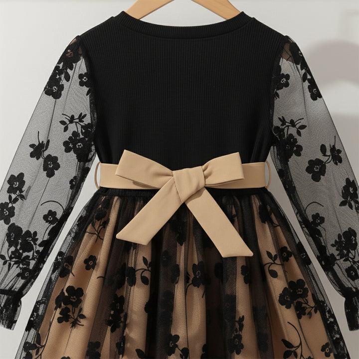 Black dress with floral sleeves and beige bow on a white background