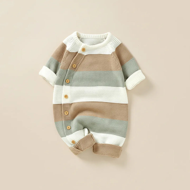 Striped baby romper with buttons on a beige background