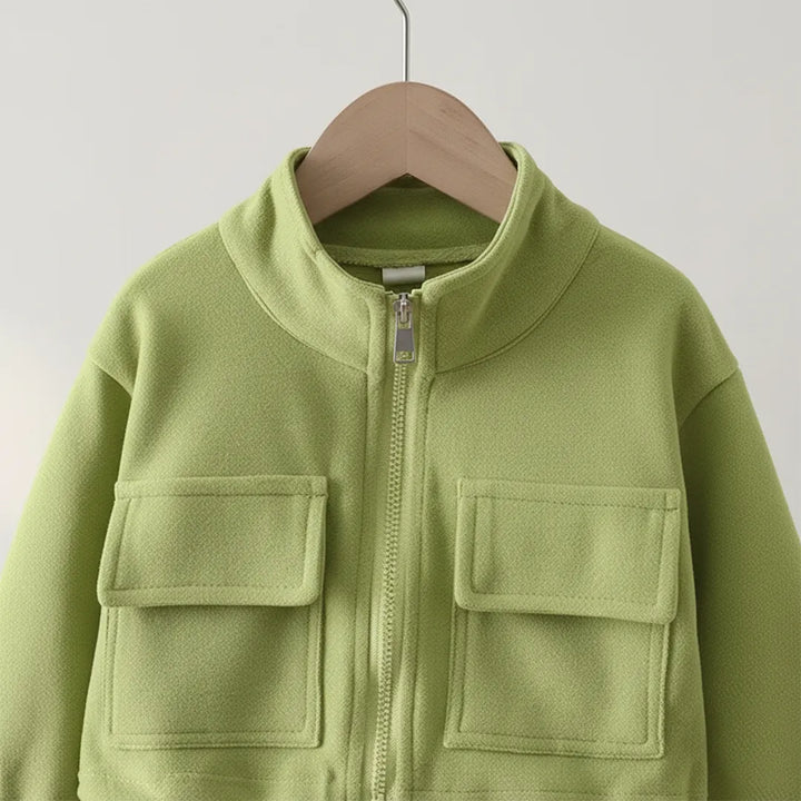 Green jacket with two front pockets on a hanger against a light gray background