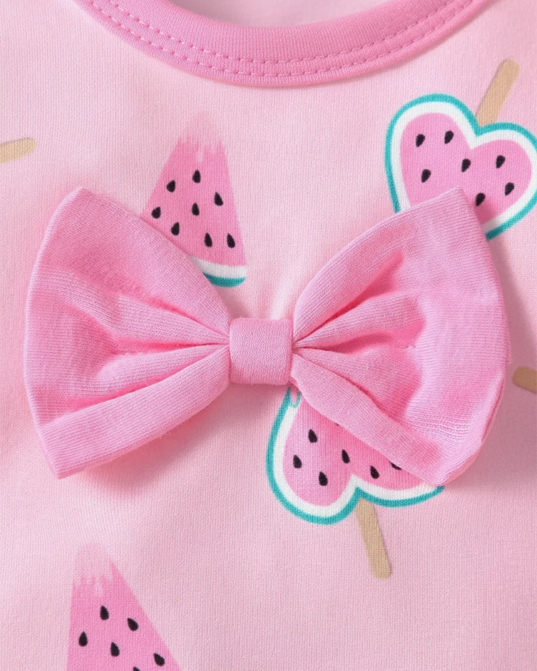 Pink outfit with a large bow and watermelon slice designs on a pink background