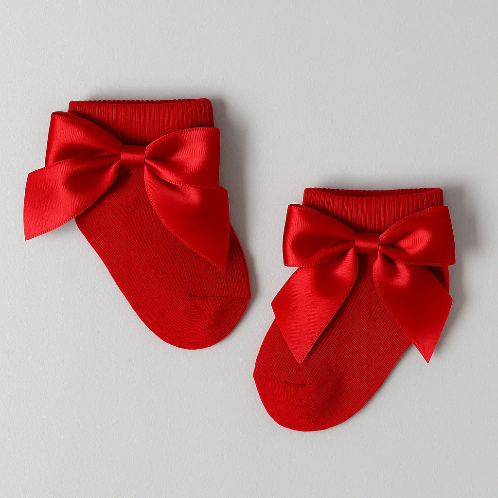 Red socks with large satin bows on a light gray background