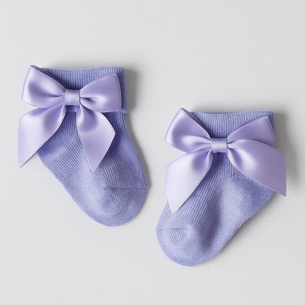 Pair of purple socks with large bows on a light gray background
