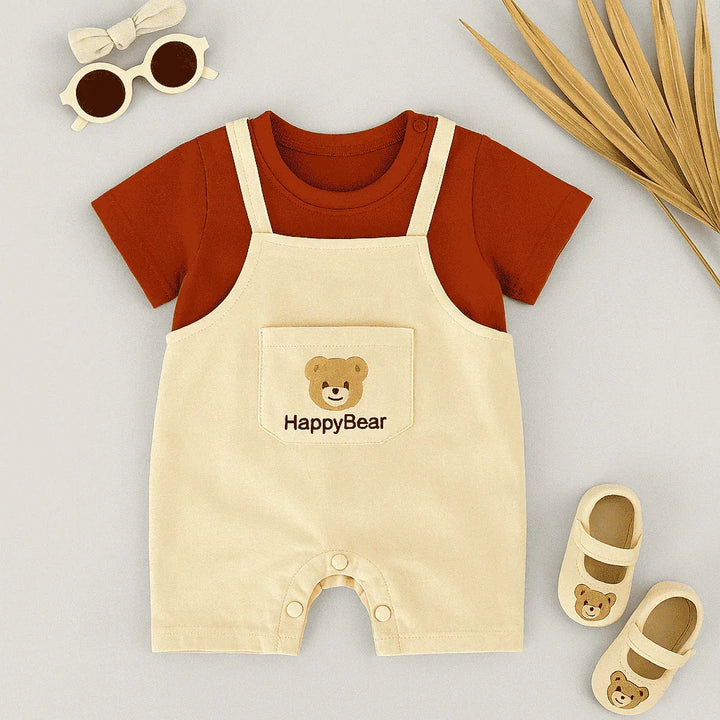 Baby outfit with red shirt and beige overalls featuring 'HappyBear' logo, accompanied by baby shoes and sunglasses on a light gray background.