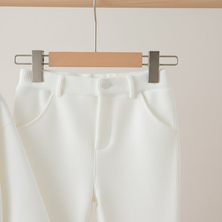 White pants on a hanger against a neutral background