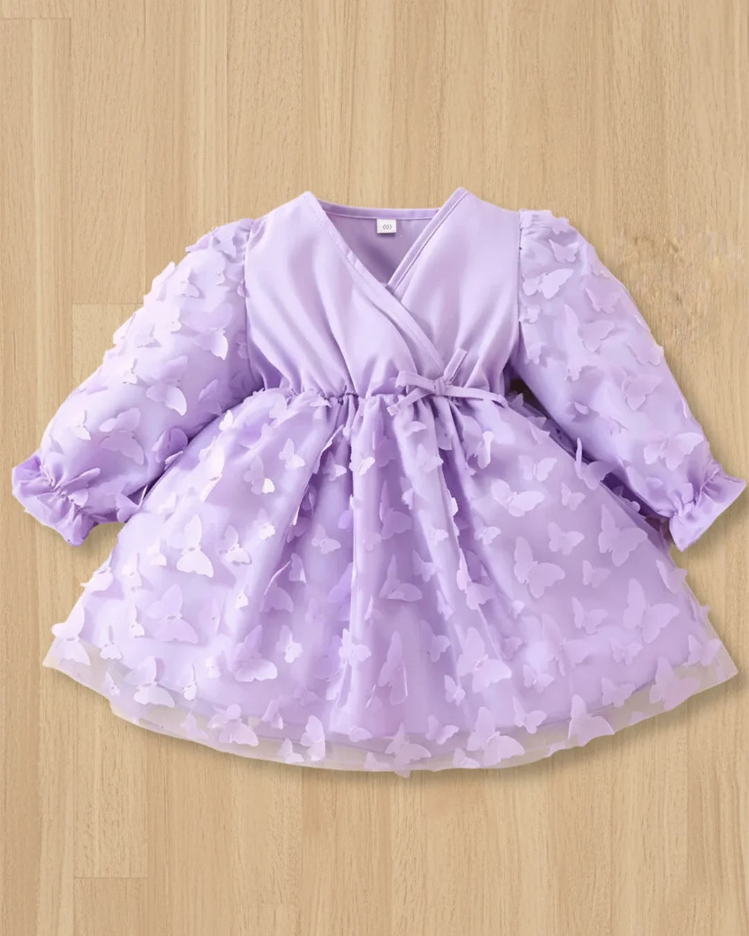 Purple dress with star pattern on a wooden surface