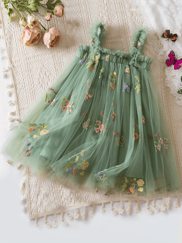 A green mesh dress for girls with a floral pattern, displayed on a white background with decorative flowers and butterflies.