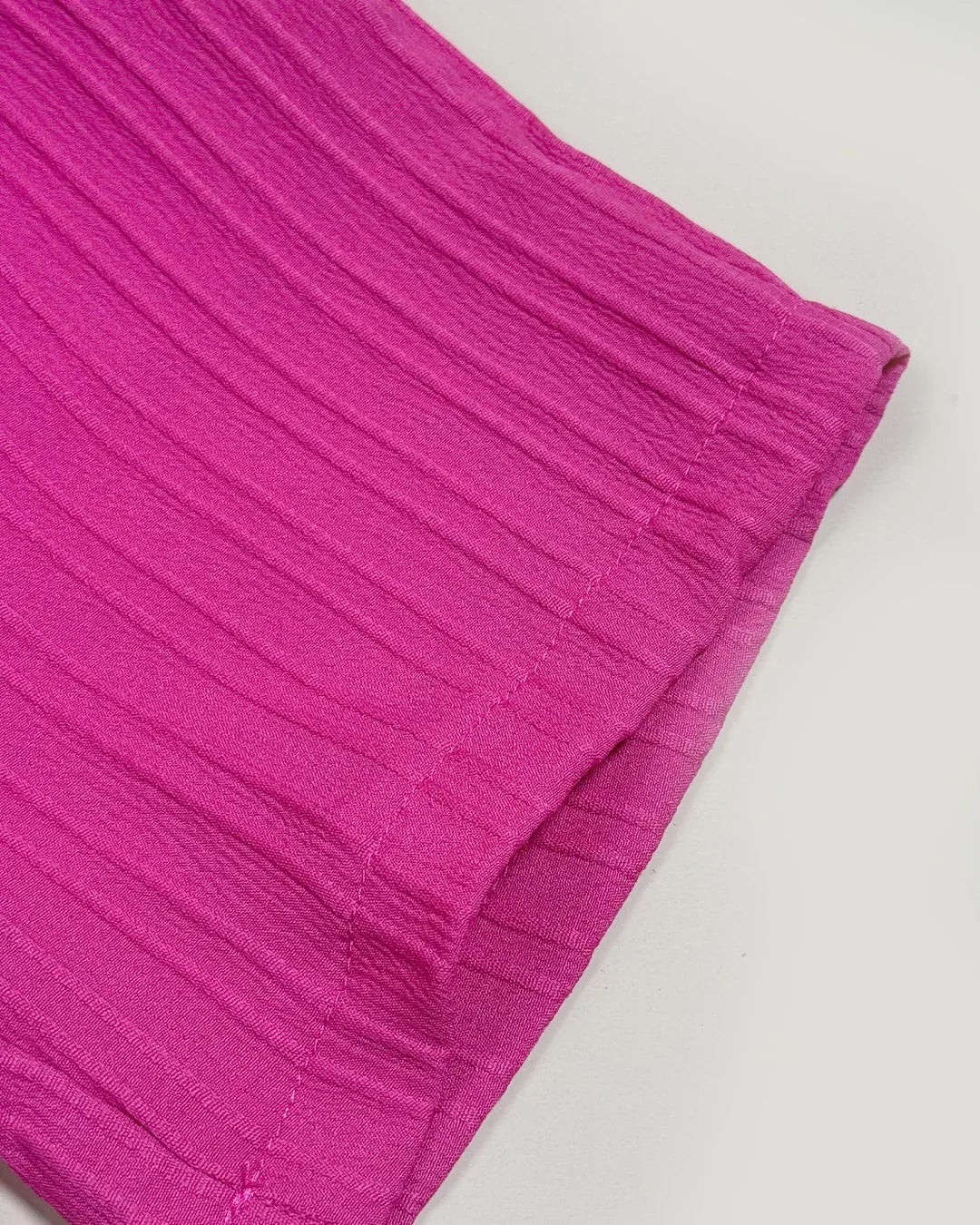 Close-up of a pink textured fabric on a light gray background