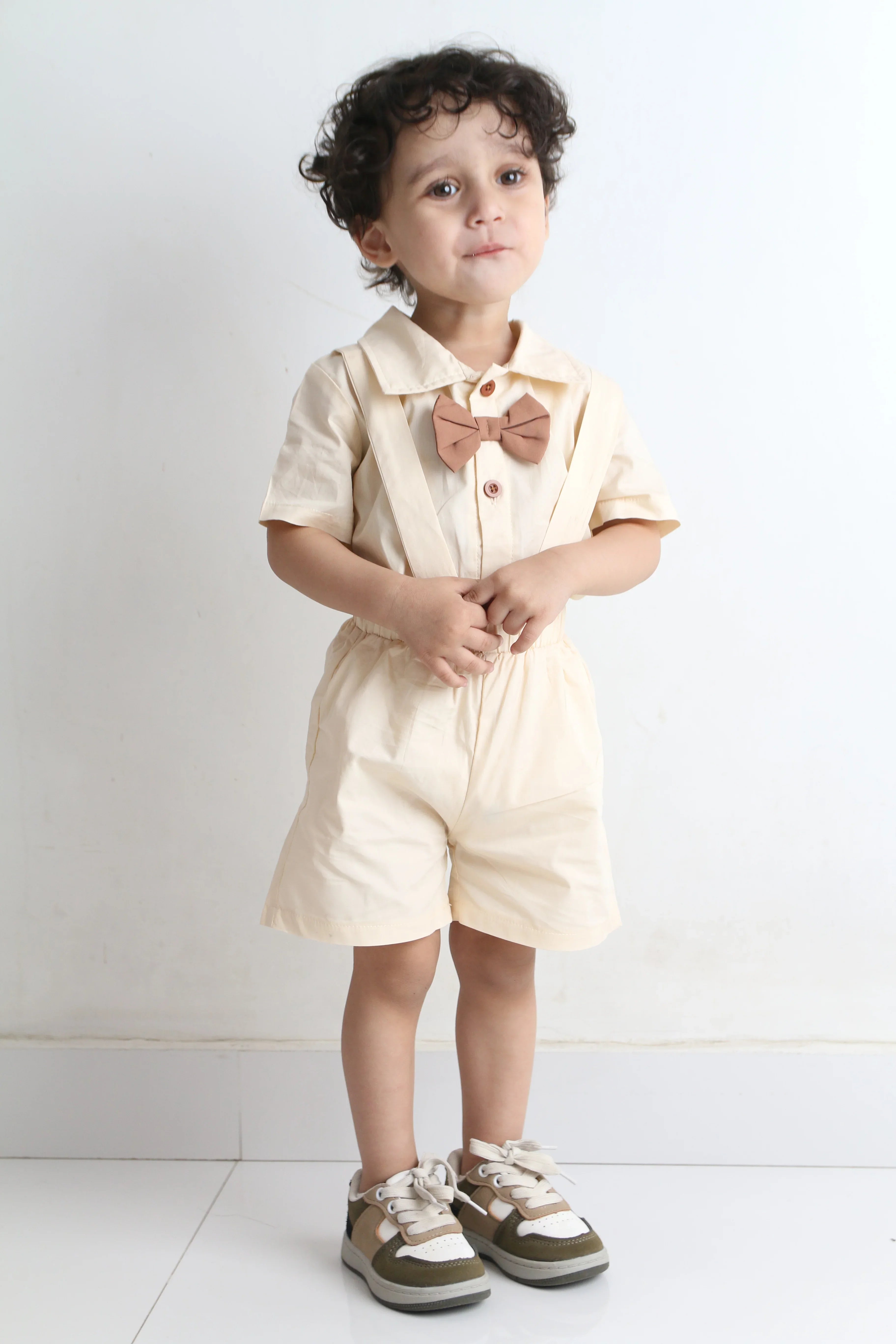 Child in a white dress standing on a light gray floor