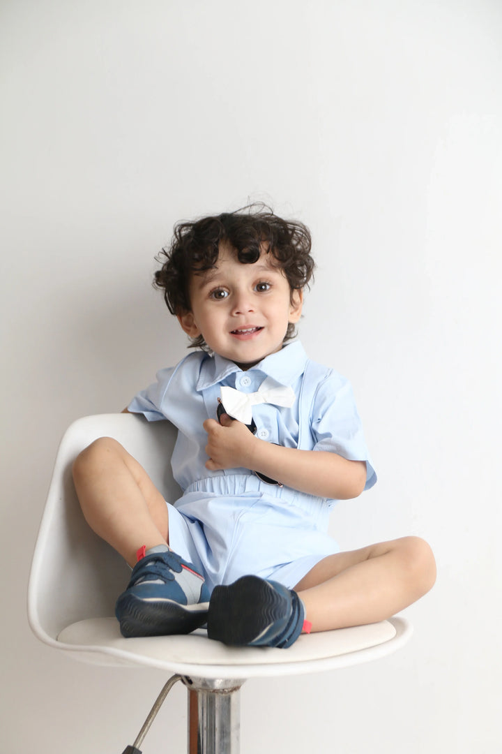 Child sitting on a chair with feet up, wearing a blue shirt and jeans.