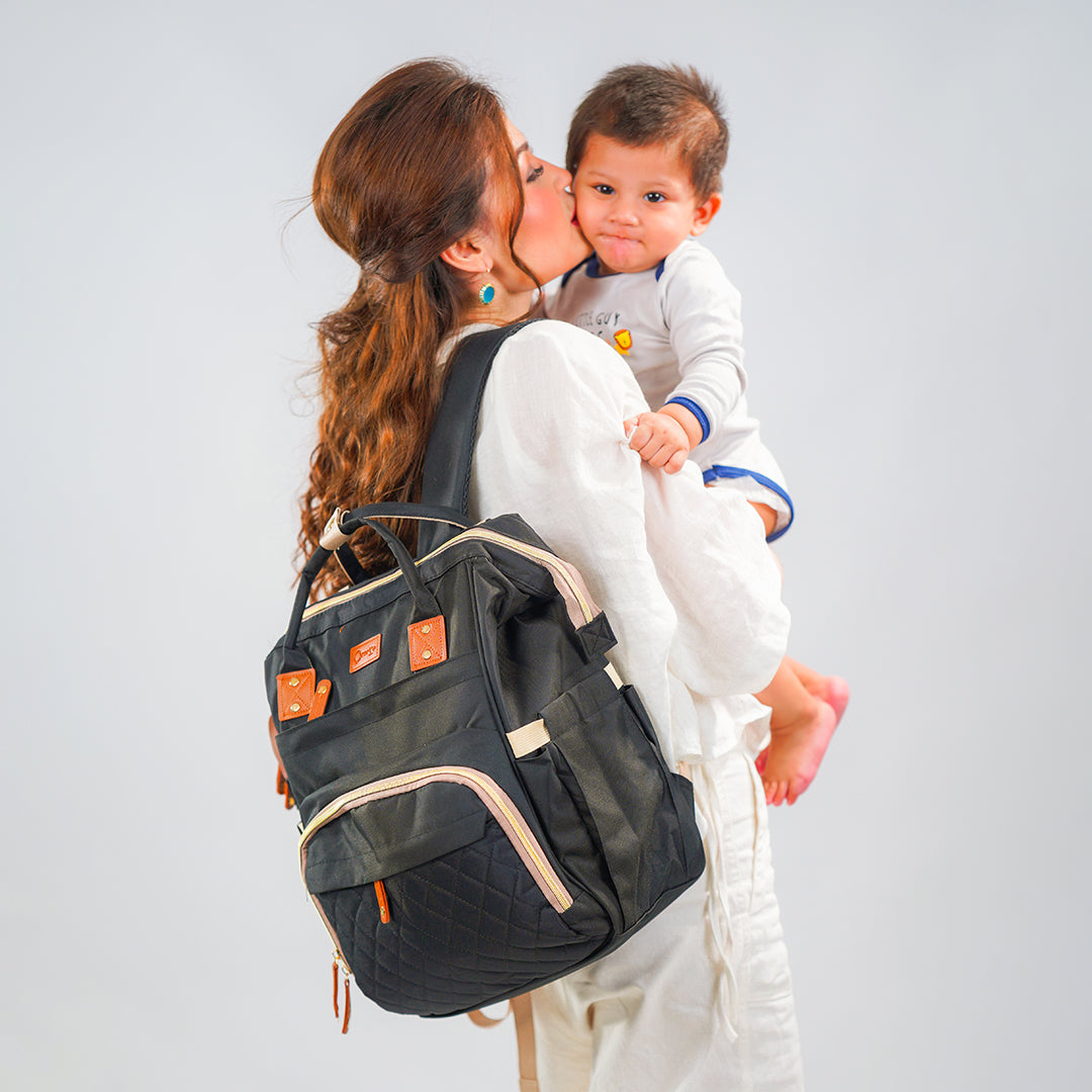 mom with baby wearing black maternity bag