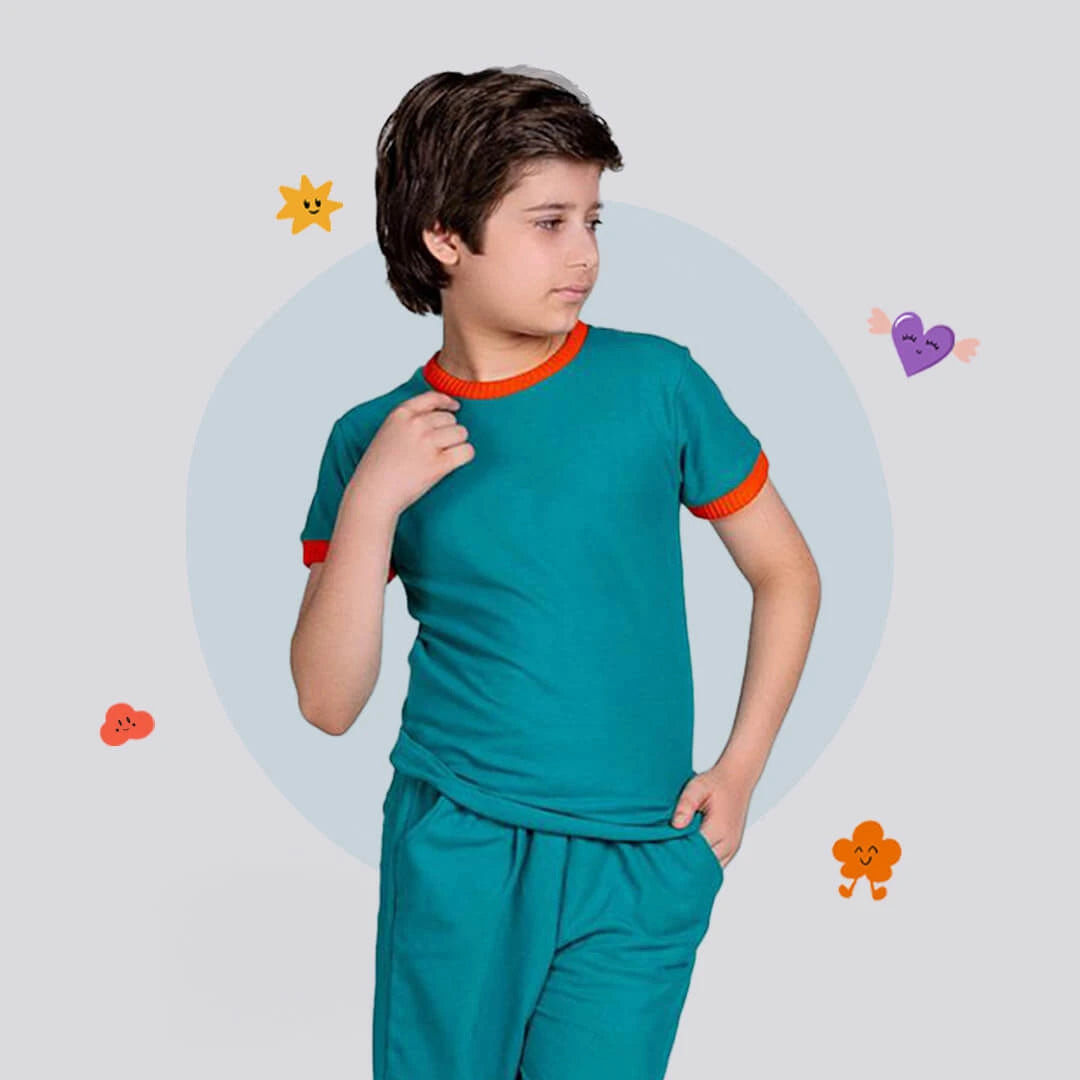 Child wearing a teal outfit with orange trim on a light gray background