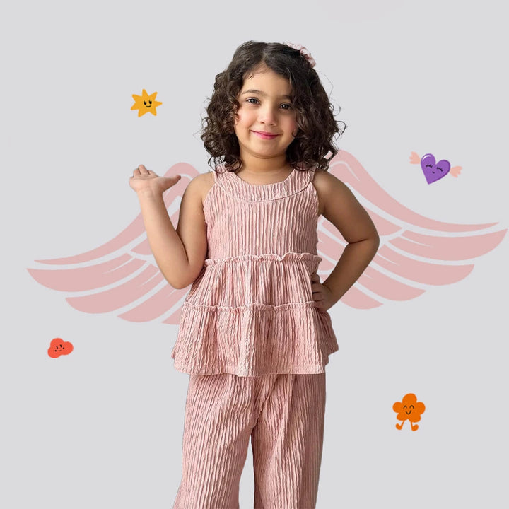 Young girl in a pink outfit with angel wings and hearts on a light gray background