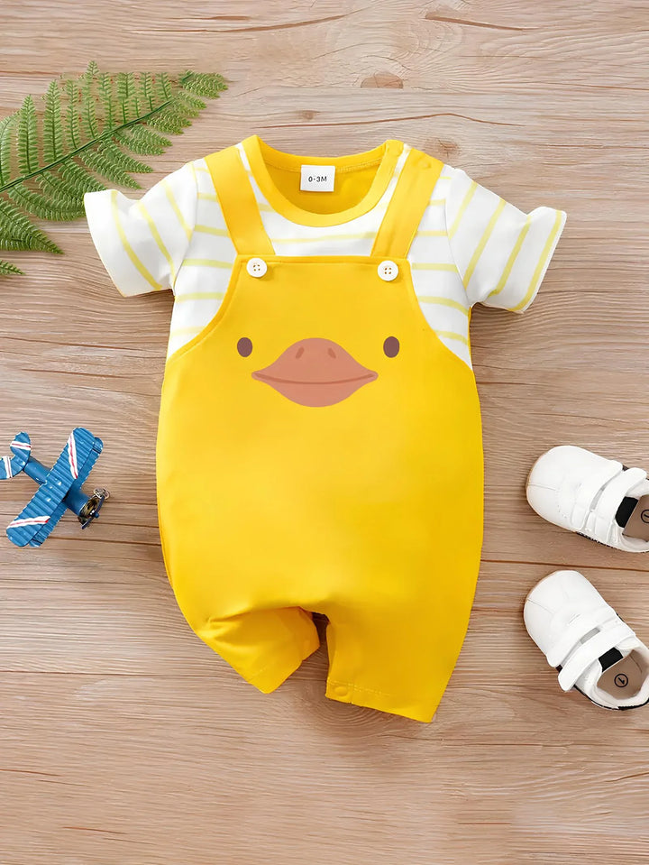 Yellow baby romper with duck design on a wooden surface