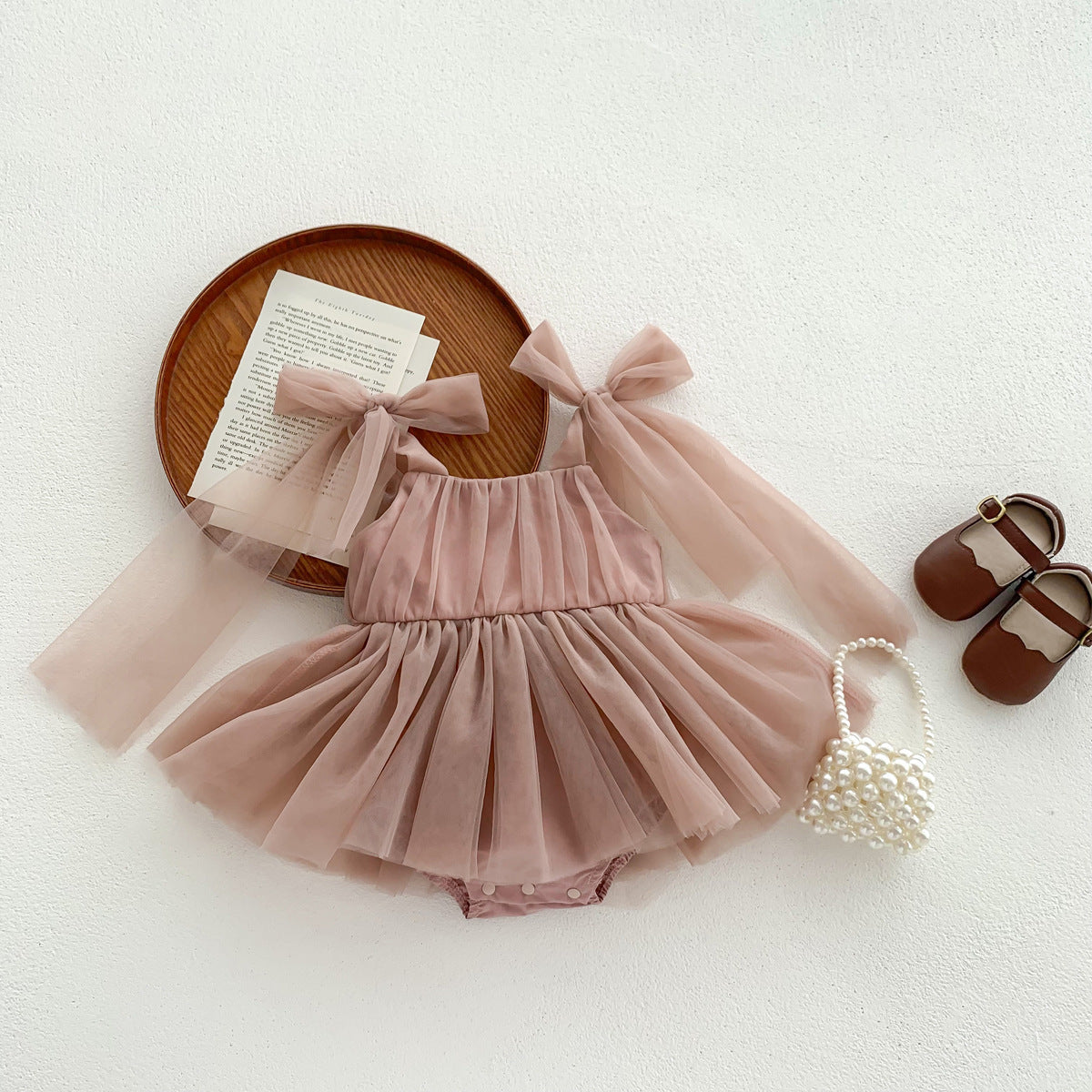Pink tulle romper with matching headband and shoes on a white background