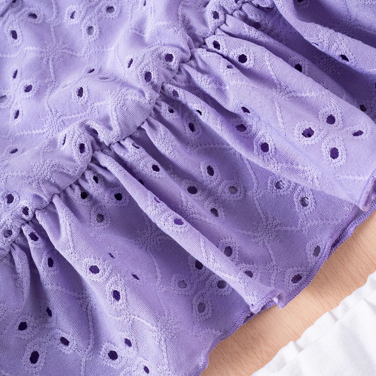 Close-up of a purple lace fabric with a floral pattern
