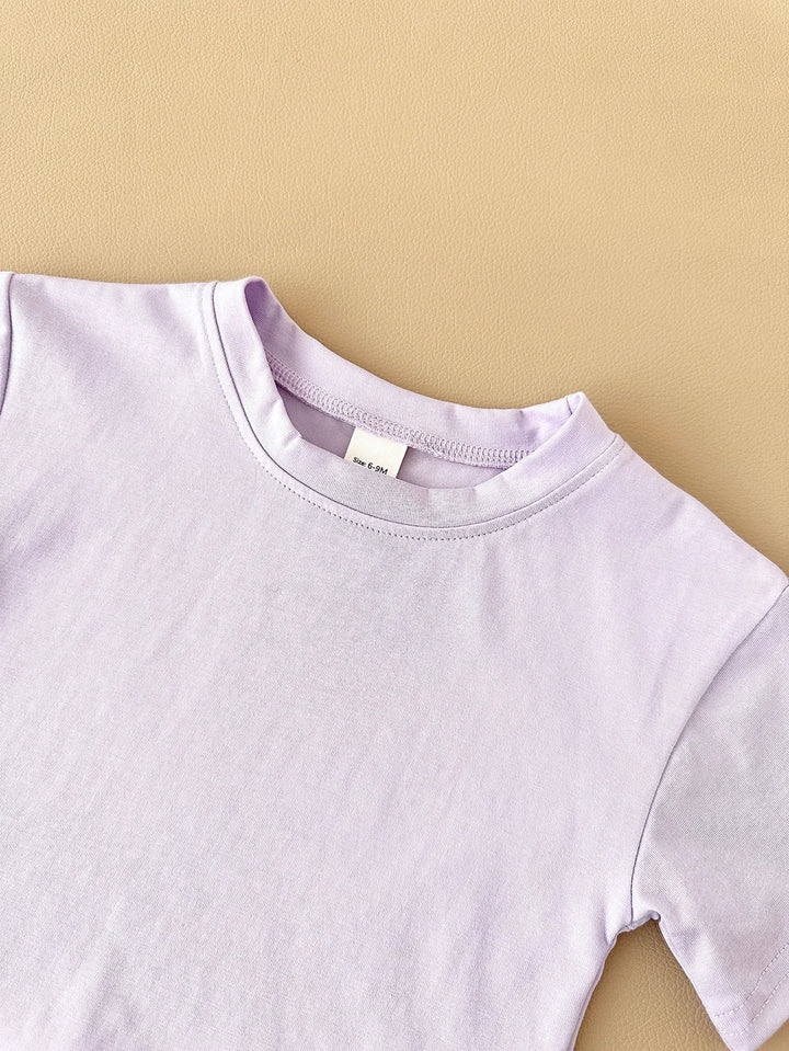 Close-up of a light purple t-shirt on a beige background
