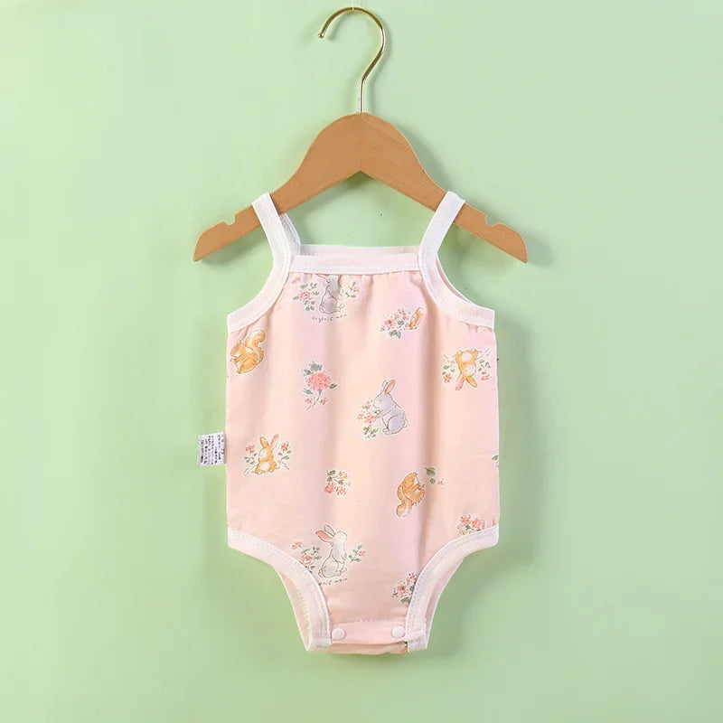 Baby romper with animal prints on a wooden hanger against a light green background