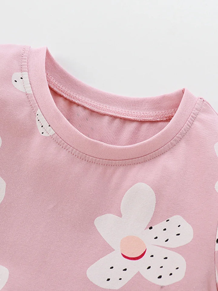 Close-up of a pink shirt with a white flower design on a light background