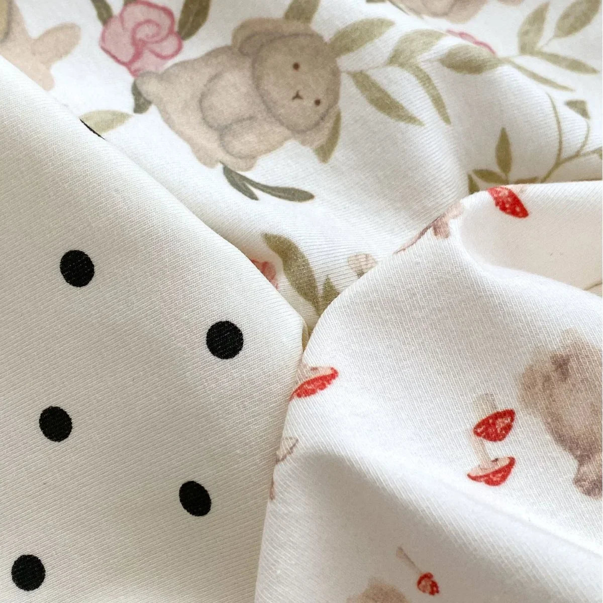 Close-up of fabric with black polka dots and bear print