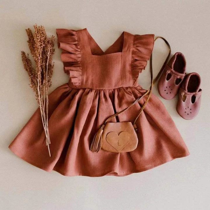 Children's rust-colored dress with matching shoes and a heart-shaped bag on a light background