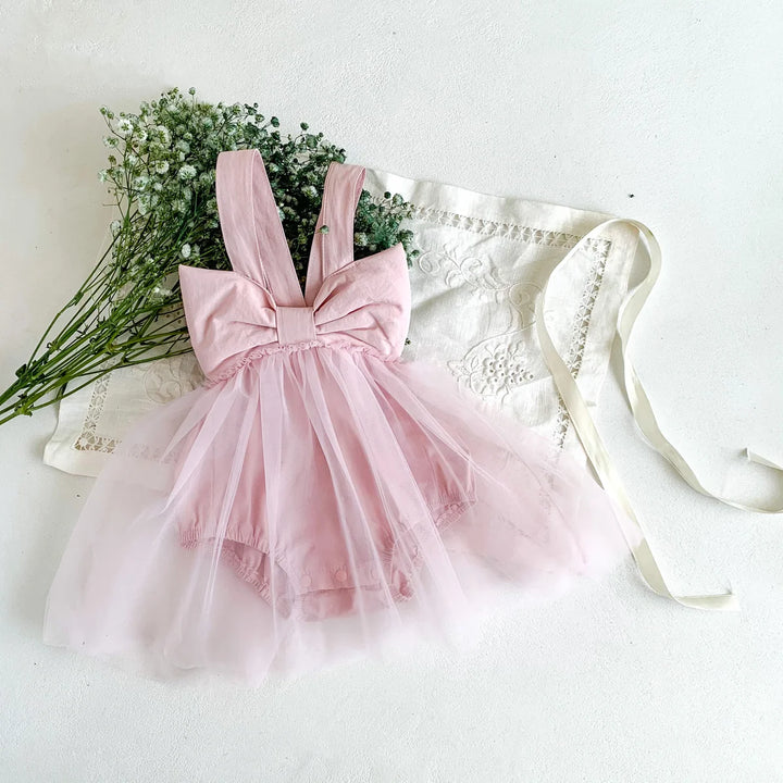 Pink dress with a large bow on a white background