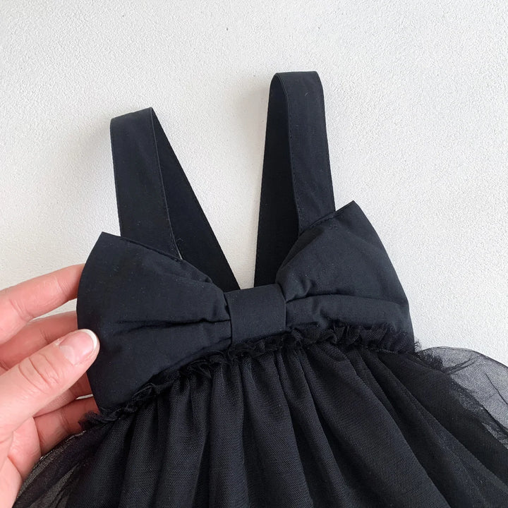 Black dress with a large bow detail on a white background