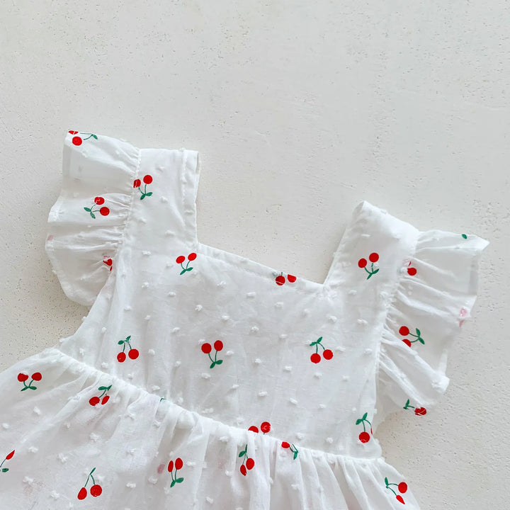 White dress with red cherry embroidery on a light gray background