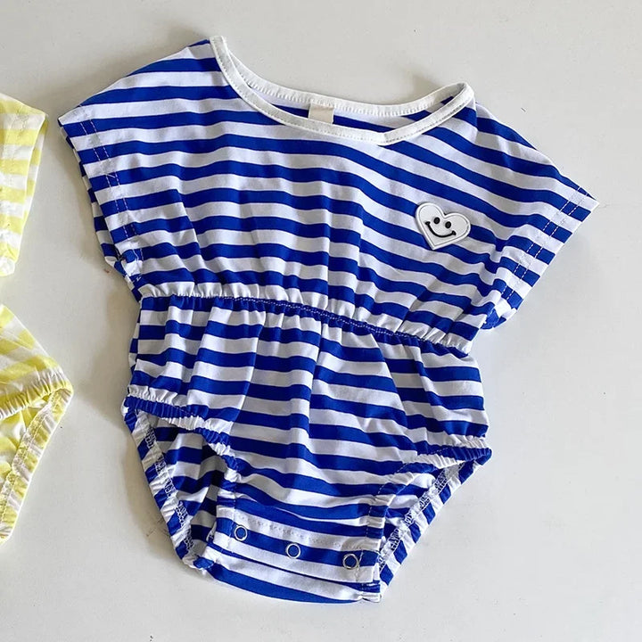 Blue and white striped baby romper with a heart design on a light gray background